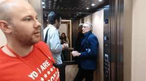 Joel Schumacher in a lift getting babbled at